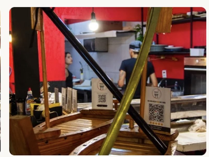 Barcos de madeira decorativos no balcão, com a cozinha ao fundo
