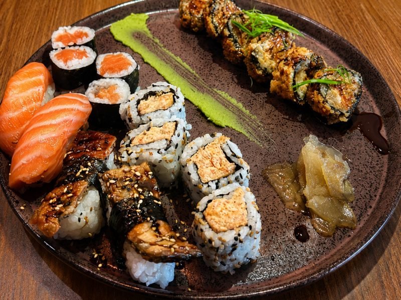 Combinado de sushi em prato redondo, com niguiris, uramakis e sashimi