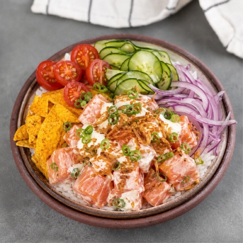 Poke em tigela, com salmão em cubos, cebola roxa, pepino, tomate-cereja e nachos